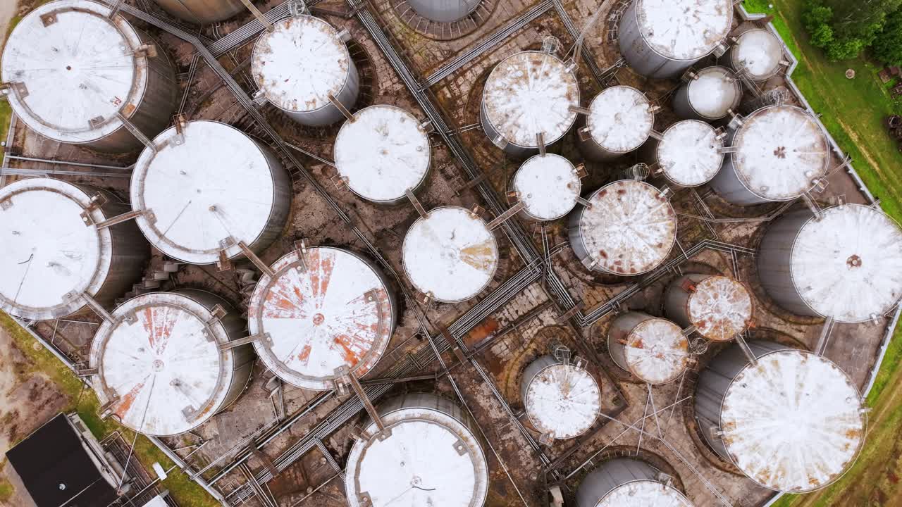 Vast fuel depot in rural Latvia framed by railway lines and farmland patterns