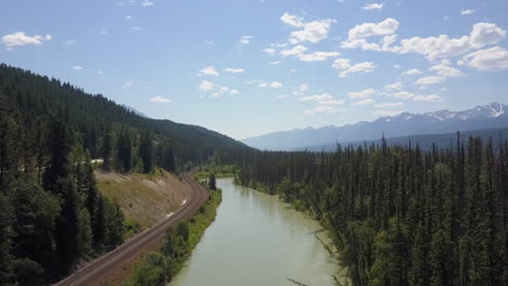 descenso aéreo al río bow y las vías del tren en las montañas rocosas canadienses