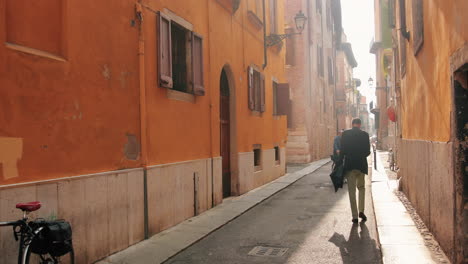 Clip-De-Cámara-Lenta-De-Una-Calle-Estrecha-En-Verona,-Italia,-Con-Un-Hombre-De-Negocios-Caminando-Por-Ella