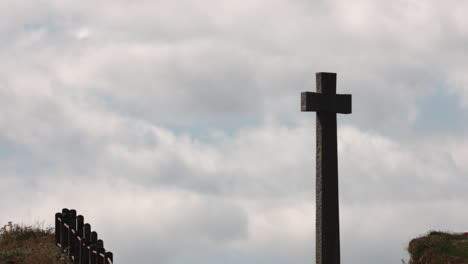 Zoom-En-El-Lapso-De-Tiempo-De-Un-Monumento-Conmemorativo-De-La-Cruz-De-Piedra-Del-Pueblo-Con-Un-Hermoso-Cielo-Azul-Y-Nubes-Moviéndose-En-El-Fondo