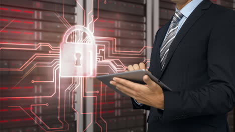 businessman using tablet computer in front of locked server tower