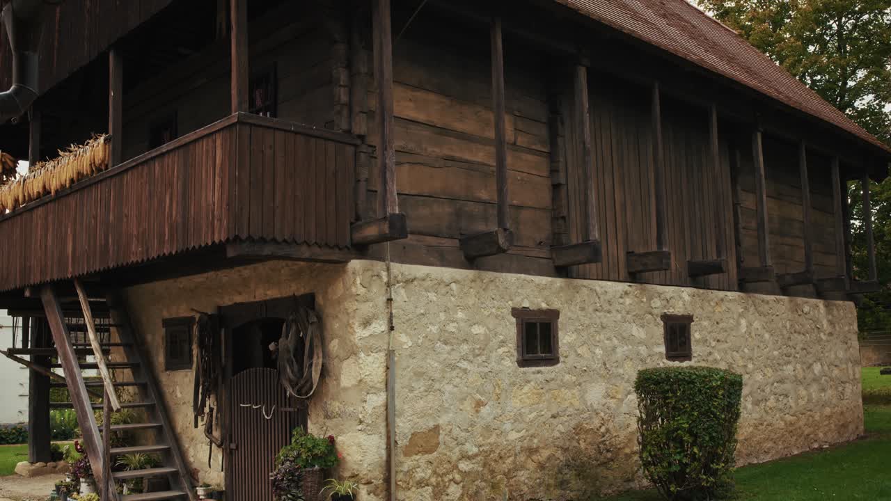 Rustic stone and wooden barn structure with plants at Kumrovec, Croatia