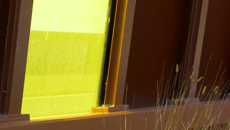 Traffic-Sound-Barrier,-Yellow-Perspex-Window-Shows-Traffic,-TILT-UP