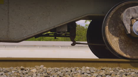 close shot of rusty train wheel slowly rolling on train track and coming to a stop