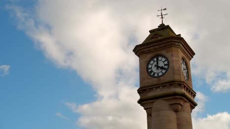 Timelapse-De-Un-Reloj-Mientras-Las-Nubes-Pasan-Por-El-Cielo-Azul-Y-Claro-En-El-Fondo