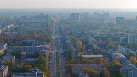 drone shot of morning mist above warsaw, poland, residential neighborhood and streets in autumn season