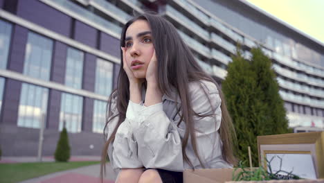 primer plano de una hermosa mujer sentada frente a un edificio de oficinas 1