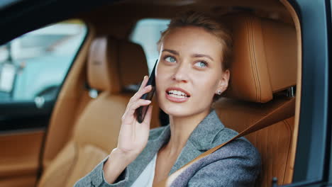 mujer de negocios sonriente mirando lejos en el coche. mujer sentada en un traje elegante en el coche