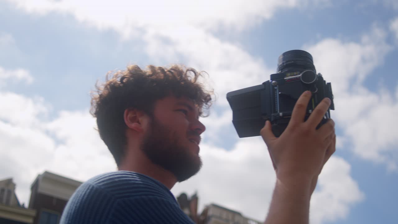 Fotografo uomo con macchina fotografica analogica a pellicola all'aperto - primo piano.