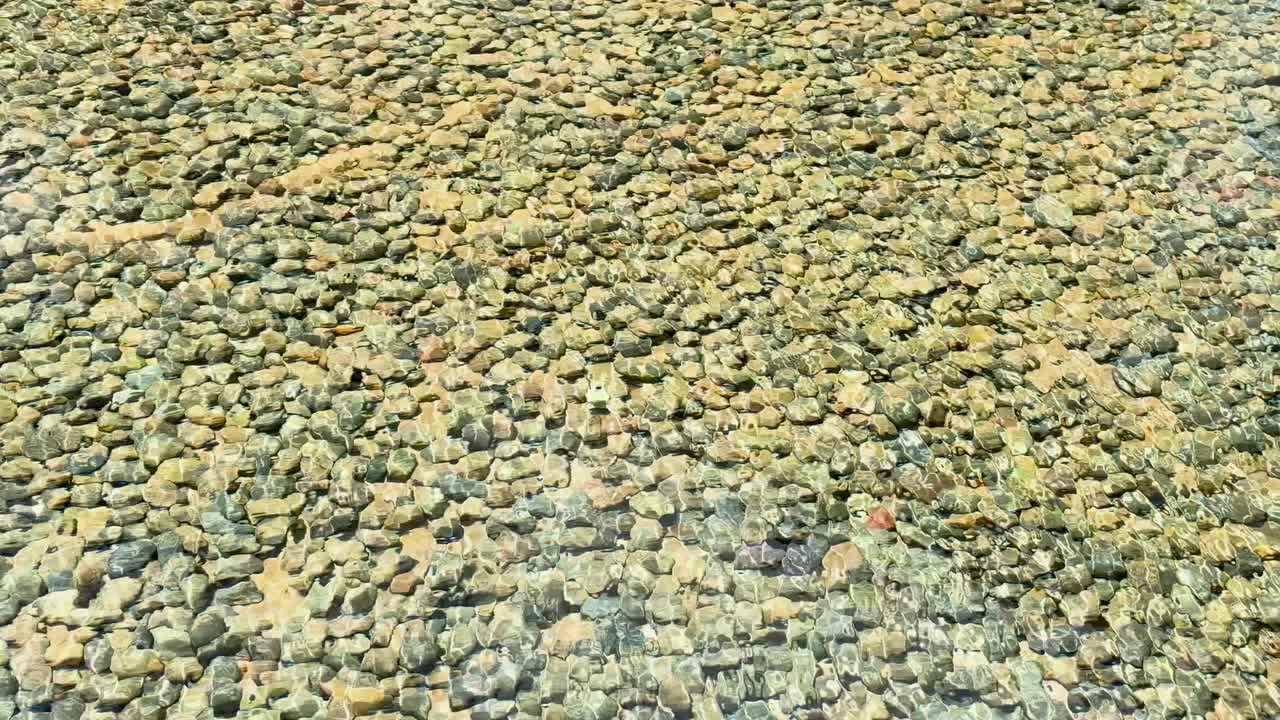 un tranquilo estanque de guijarros en phuket, tailandia, con suaves ondas de viento que crean un efecto calmante en la superficie del agua