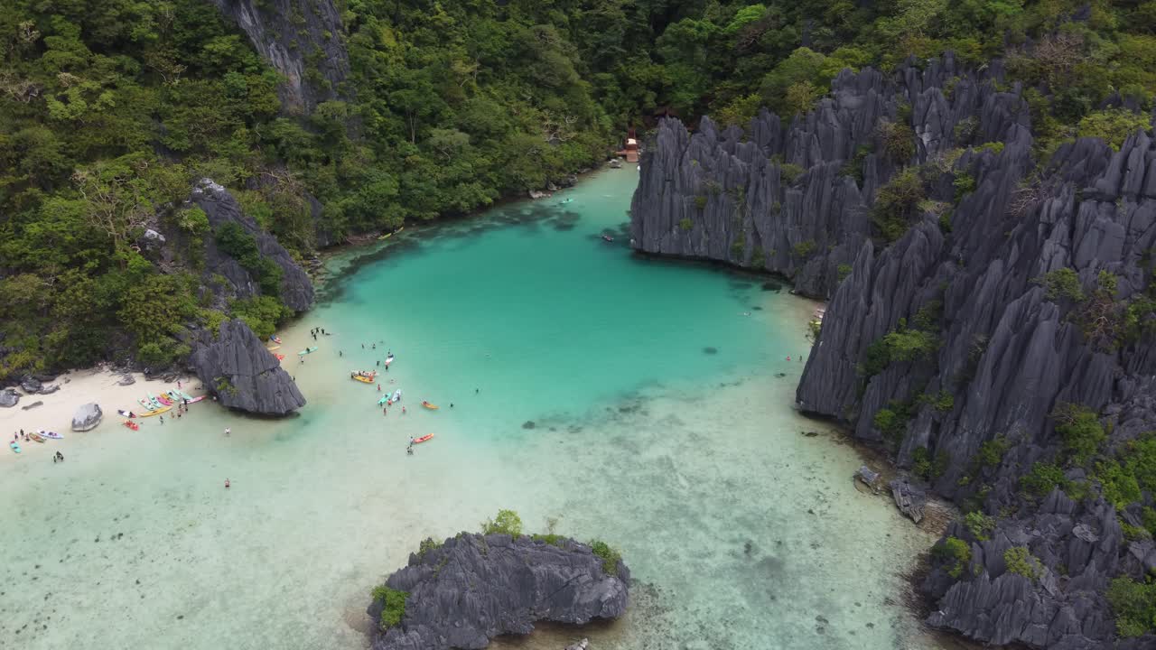 Urlauber schwimmen und fahren Kajak im türkisfarbenen Wasser der Cadlao Lagune, El Nido, Luftaufnahme