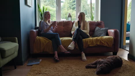 dos mujeres hablando en un sofá