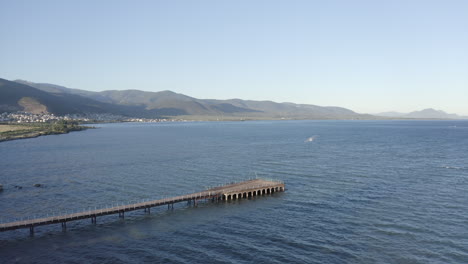 empty concrete pier on ocean coast has old stone arch construction