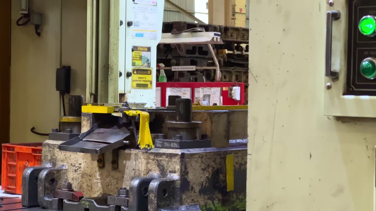 el operador opera la máquina de producción de prensas de placas metálicas