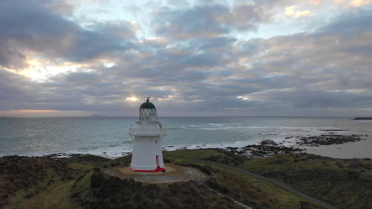 vista aérea de un faro al atardecer en las pintorescas costas de nueva zelanda