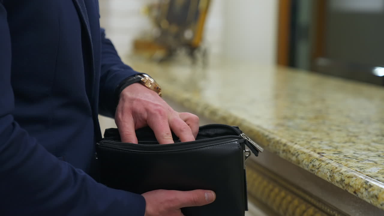 Customer paying for services in hotel. Young man paying for hotel room at reception