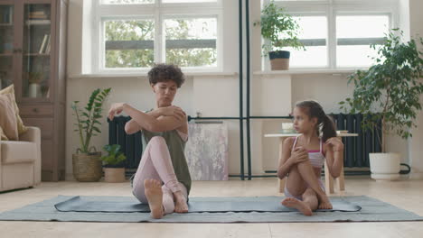madre e hija haciendo yoga en casa
