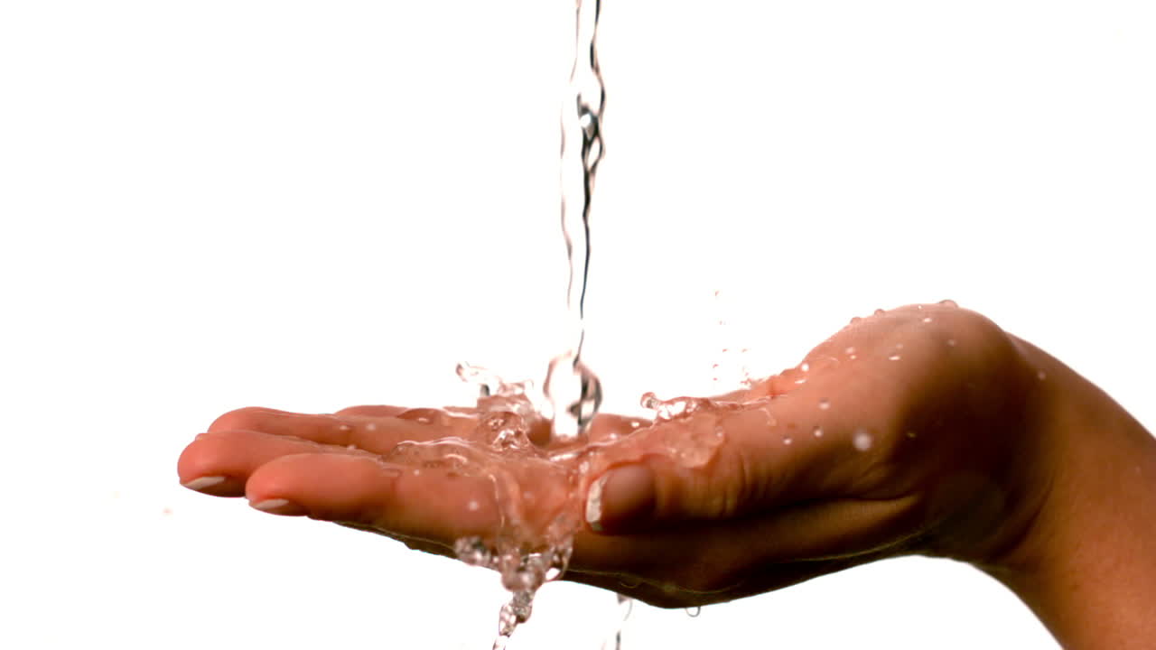 Acqua che scorre sulle mani di una donna