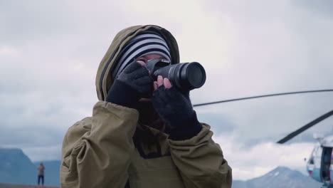 fotógrafo tomando fotos de un helicóptero cerca de las montañas