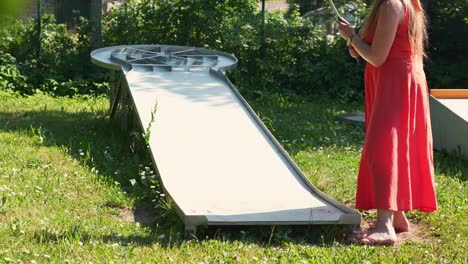 Mujer-Joven-Celebra-La-Puntuación-De-Minigolf,-La-Pelota-Golpea-En-El-Hoyo-De-Una-Sola-Vez