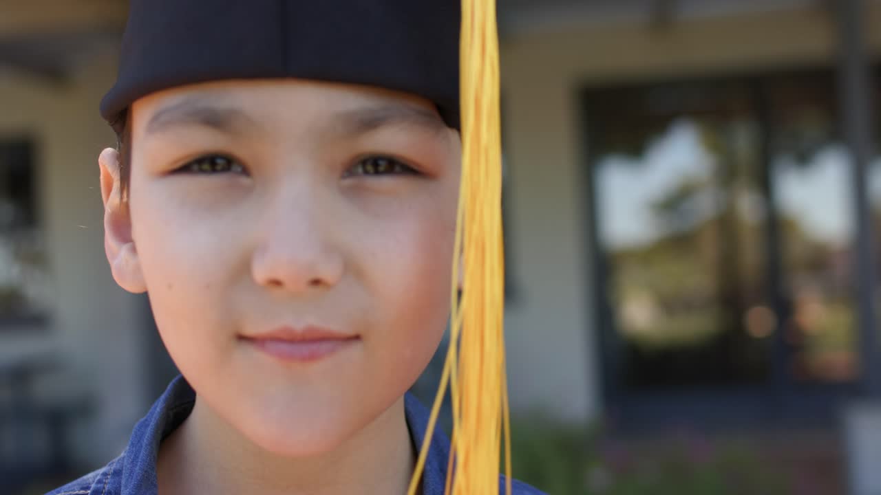 Bambina con la nappa del tocco di laurea che ondeggia, si volta verso la telecamera mentre l'inquadratura si stringe, tenendo un discorso all'ingresso.