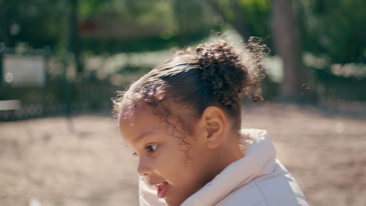 retrato de una niña juguetona saltando un columpio en el patio de recreo. niño divirtiéndose jugando