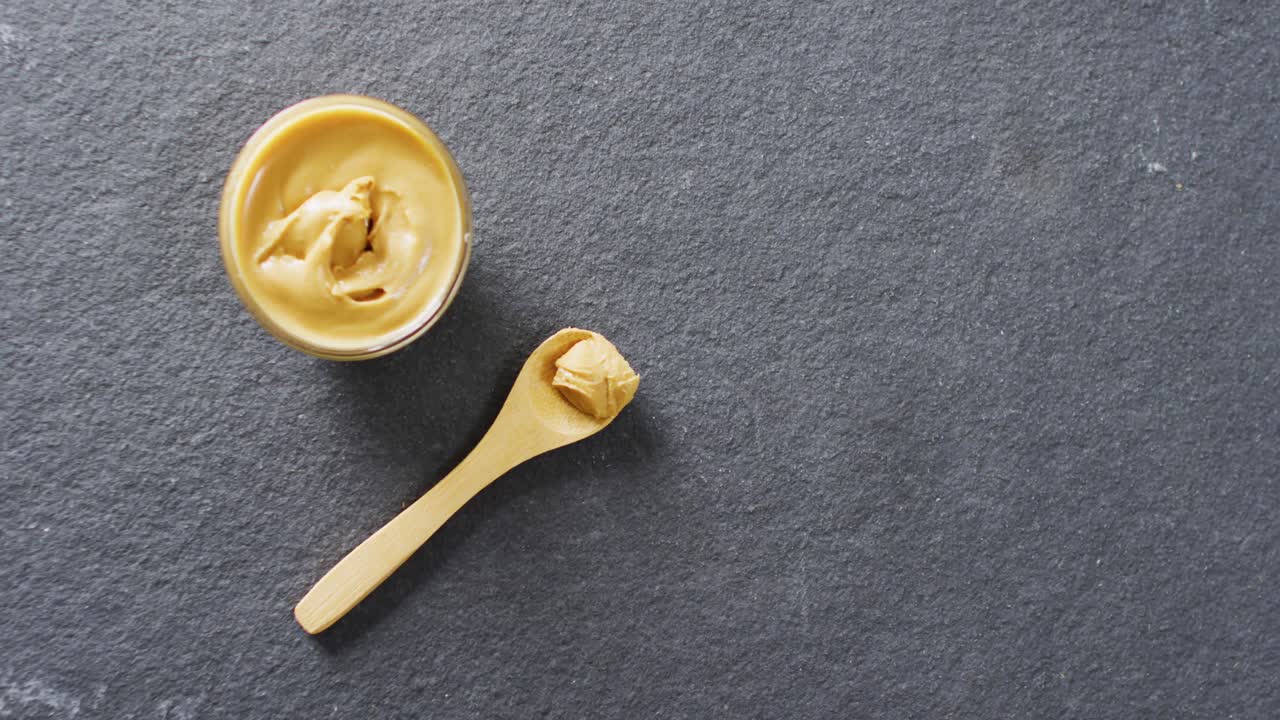 Video of close up of peanut butter on gray background
