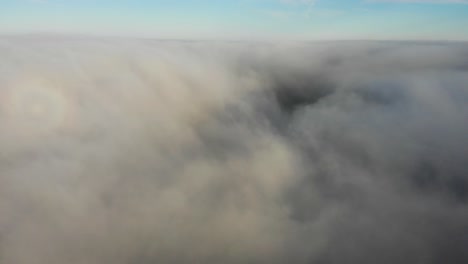 aerial rising shot through and above the clouds showing the blue sky above