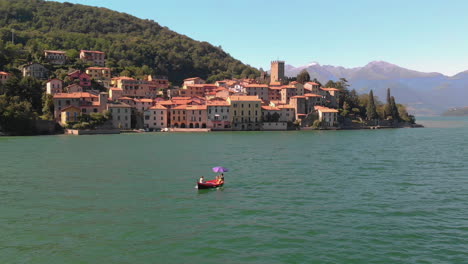 Aerial-shot-of-Italian-village-with-boat-at-lake-Como-in-Italy,-4k