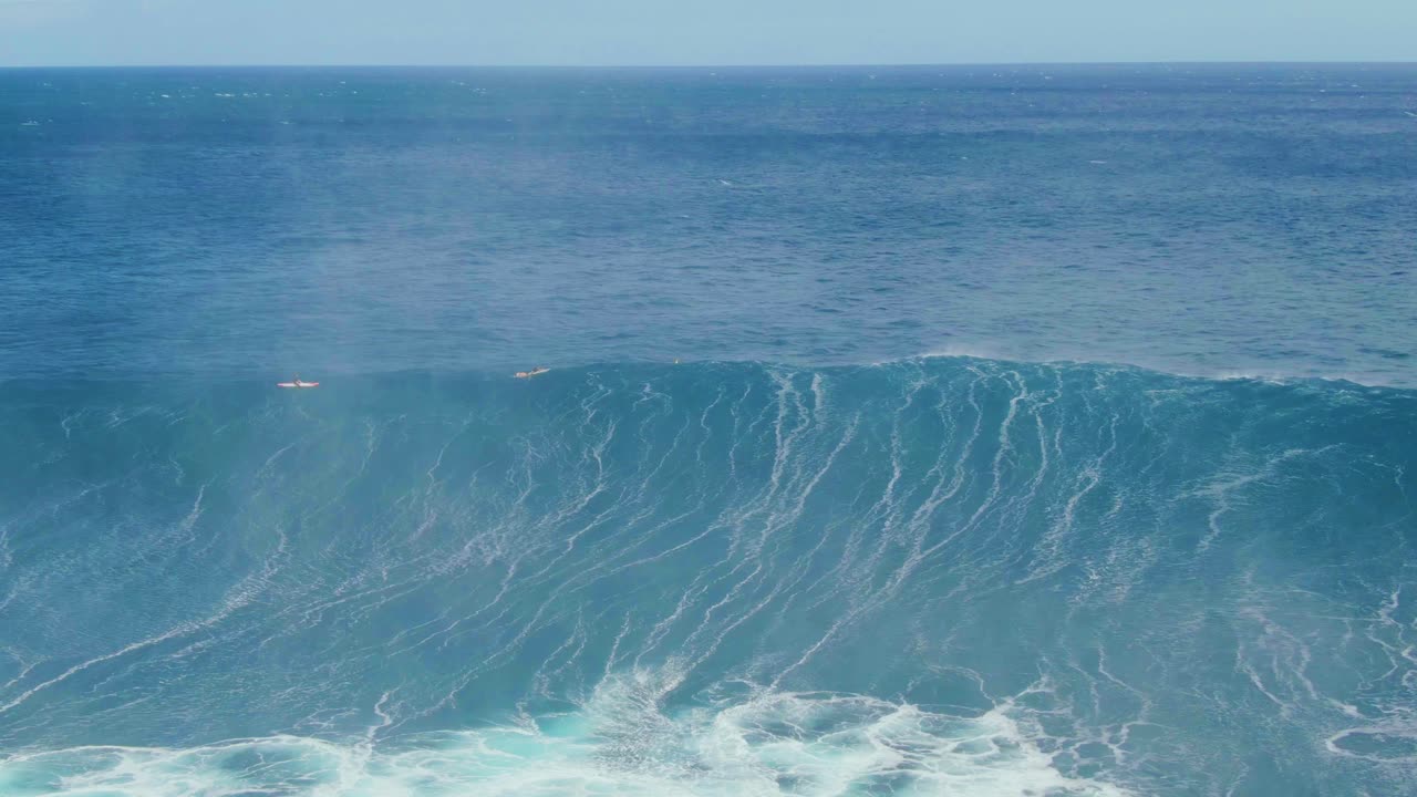 Huge white wave ideal for surf, rolling and splashing over deep blue ocean on shore of tropical island in Hawaii
