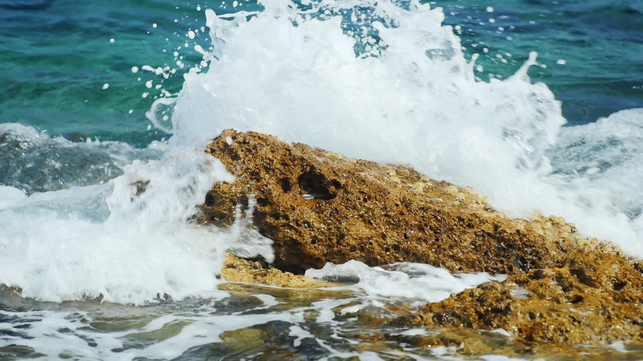 많은 물이 튀는 바위에 부서지는 바다 파도