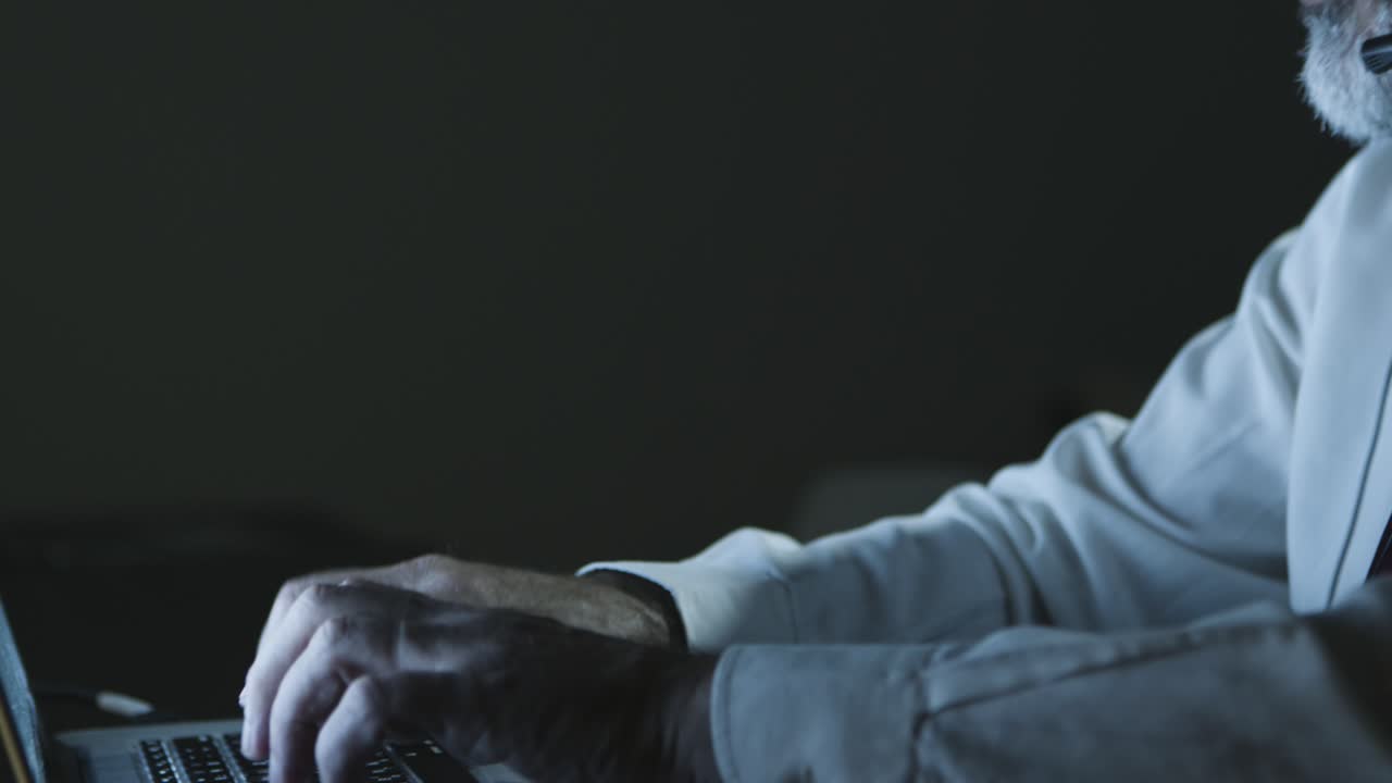 Mature businessman in headset using laptop