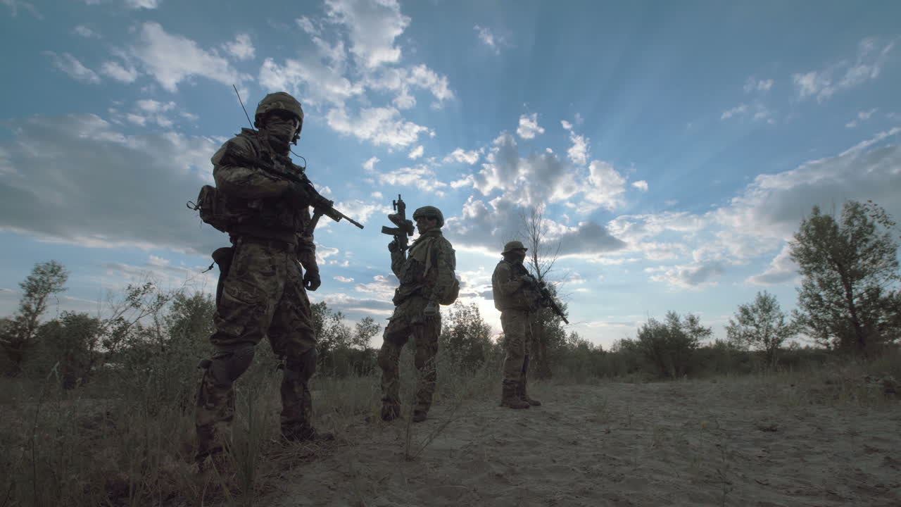 Silhouette of soldiers on patrol in a desert landscape