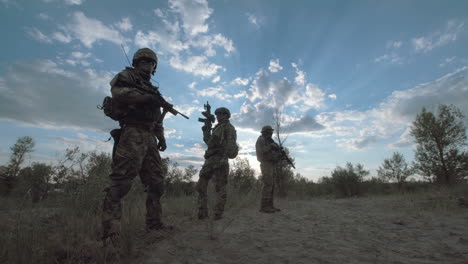 silhouette of soldiers on patrol in a desert landscape