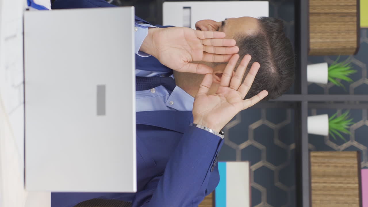 video vertical de un hombre de negocios con un aspecto asustado en la computadora portátil.