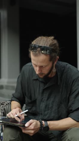 man using a tablet for digital art outdoors