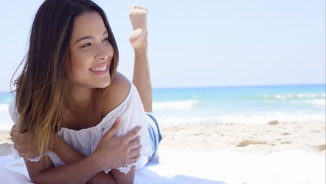 Young-woman-relaxing-in-the-shade-of-an-umbrella