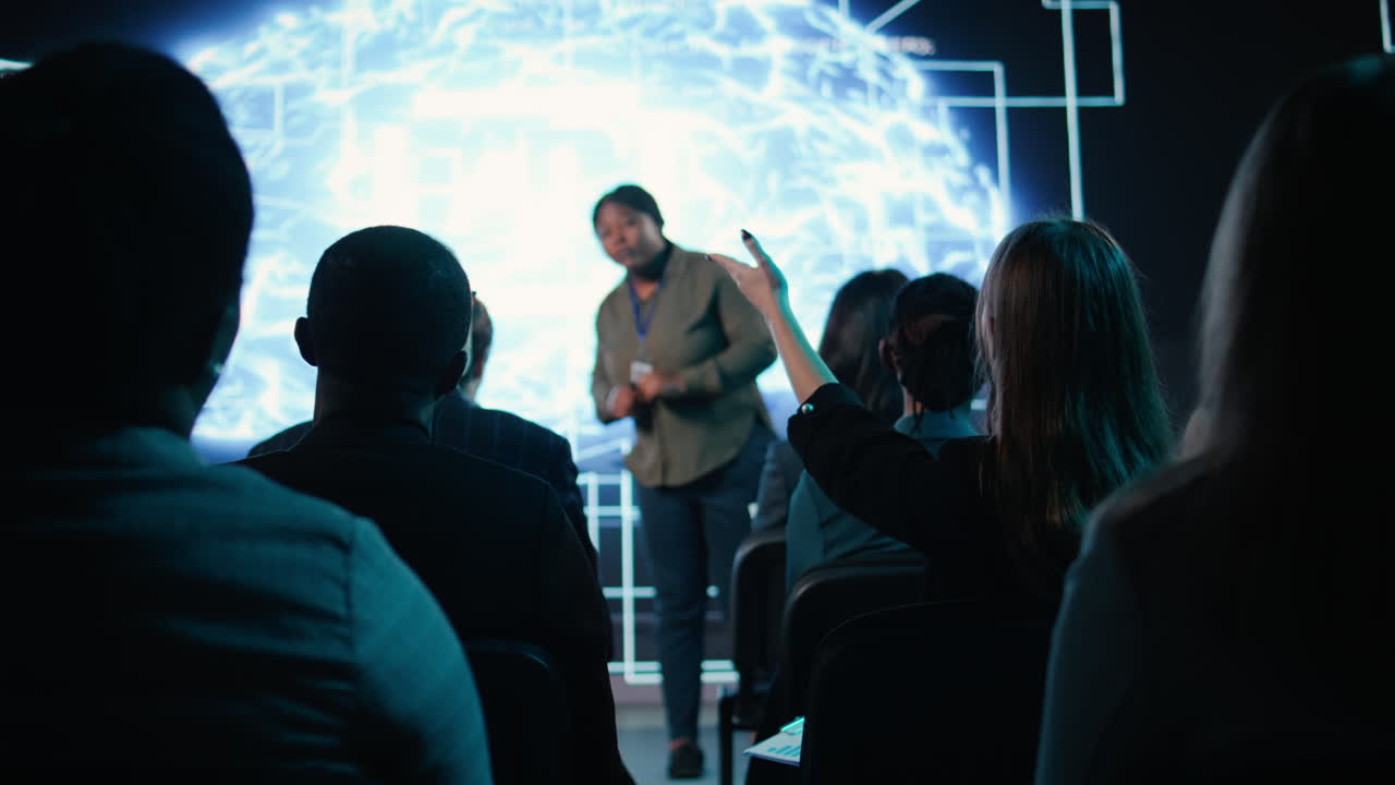 Girl in audience interacting with black female speaker presenting AI systems