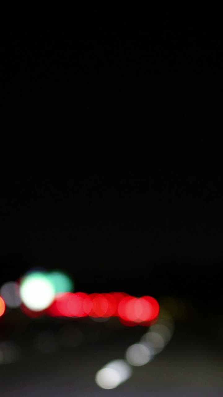 luces fuera de foco moviéndose en una carretera oscura