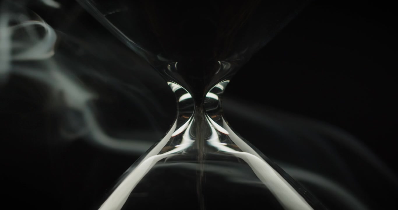 Smoke rising slowly behind an hourglass