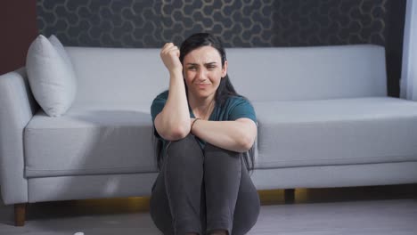 la mujer sentada junto a la pared está enojada consigo misma.