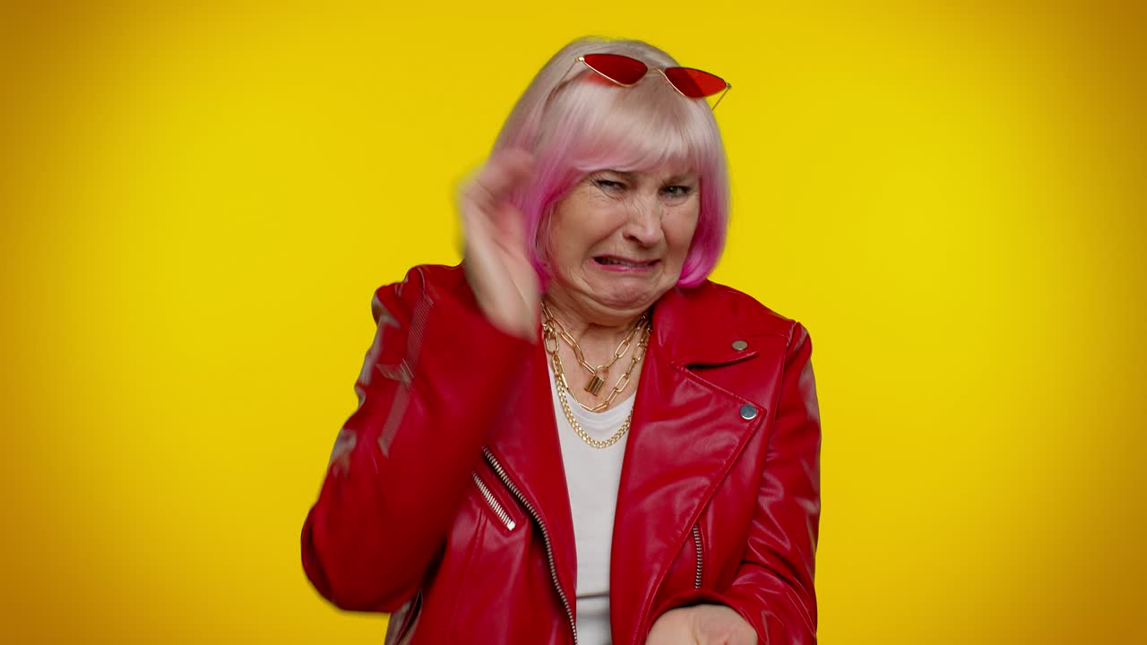 mujer mayor levantando las manos en expresión indignada, preguntando por qué, qué razón de fracaso, irritación