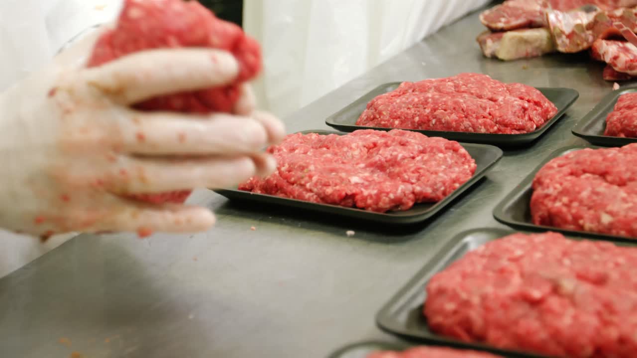 Mid section of butcher packing minced meat in container