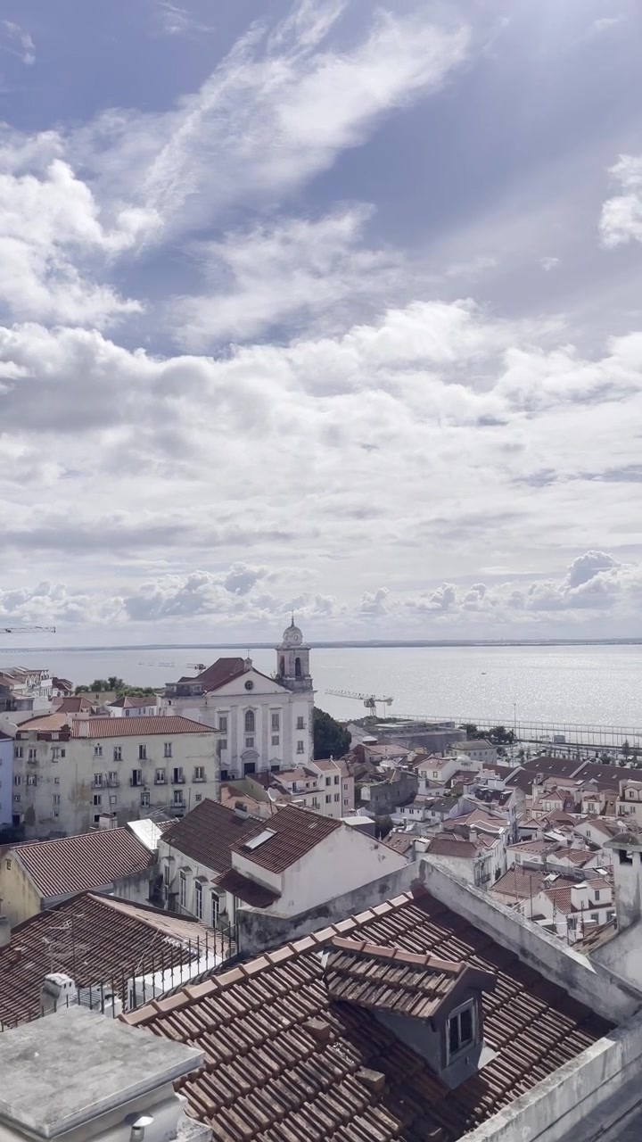 Miradouro Portas do Sol, Lisbona. Punto panoramico di Lisbona, Portogallo, attrazione turistica popolare ad Alfama. Scatto panoramico da telefono, skyline cittadino, giornata di primavera luminosa e soleggiata con nuvole.