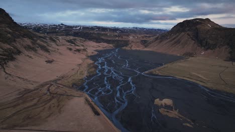 Vista-Aérea-Del-Paisaje-De-Un-Río-Que-Fluye-En-Un-Valle-De-Montaña,-En-Islandia,-En-Un-Día-De-Mal-Humor