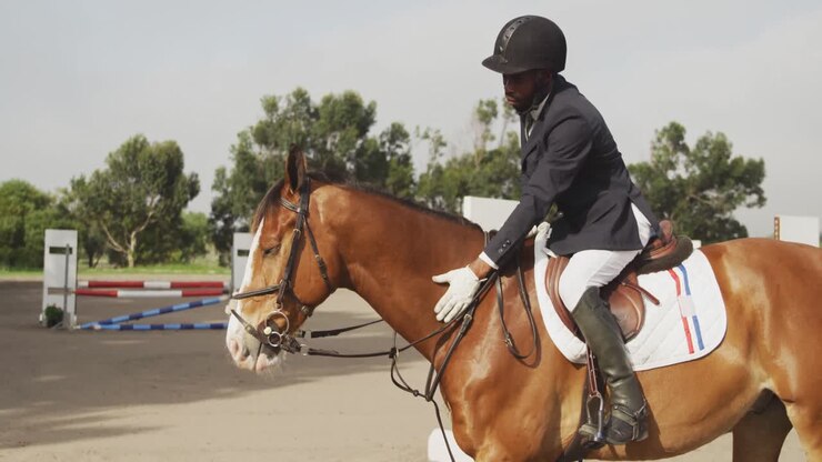 Uomo afroamericano che cavalca il suo cavallo da dressage