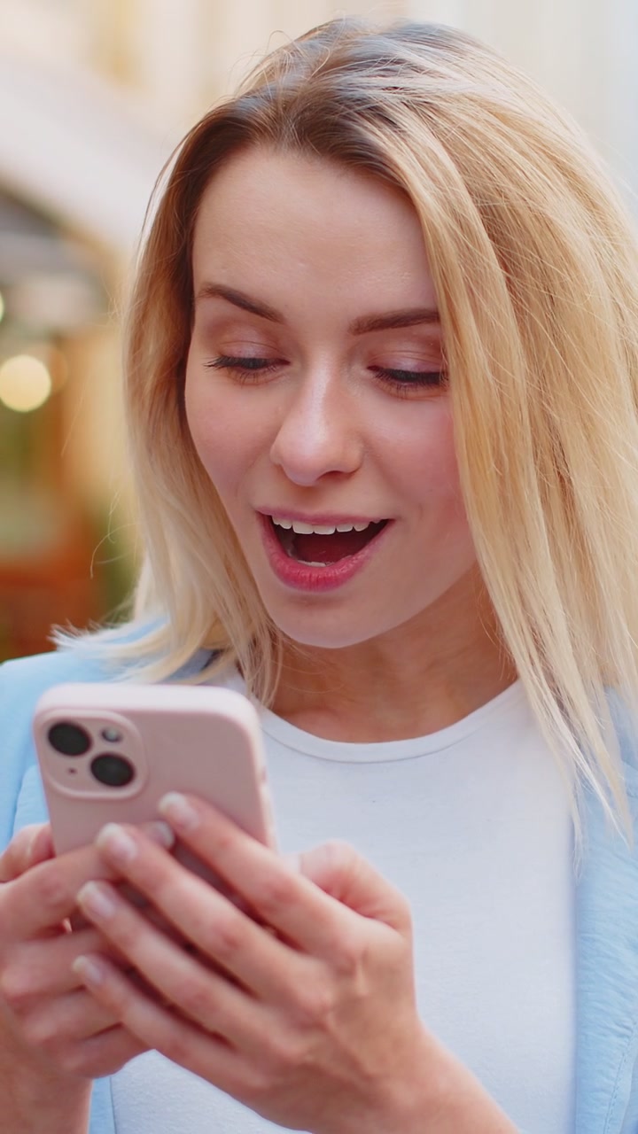 Eccitata felice vincitrice donna usa smartphone guardando lo schermo stupita festeggiando la vittoria buone notizie di messaggio