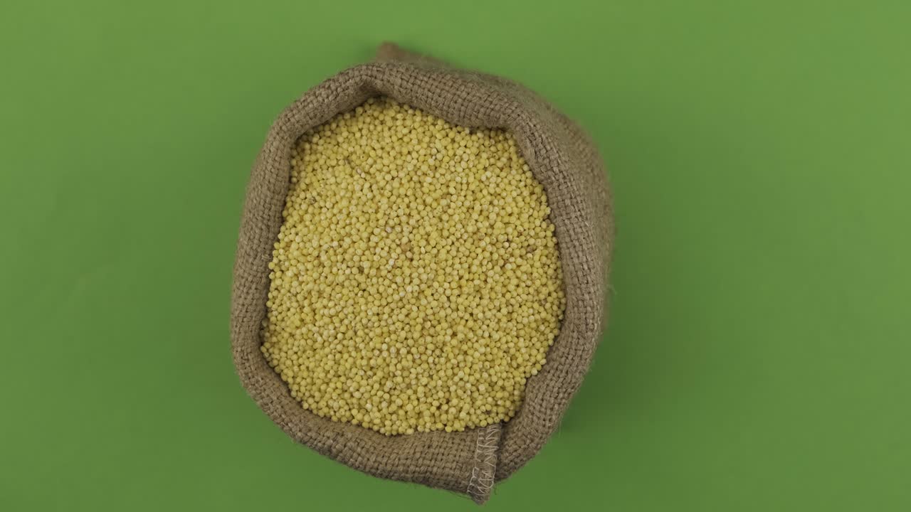 Rotation of a full sack of millet grain. Top view. Isolated