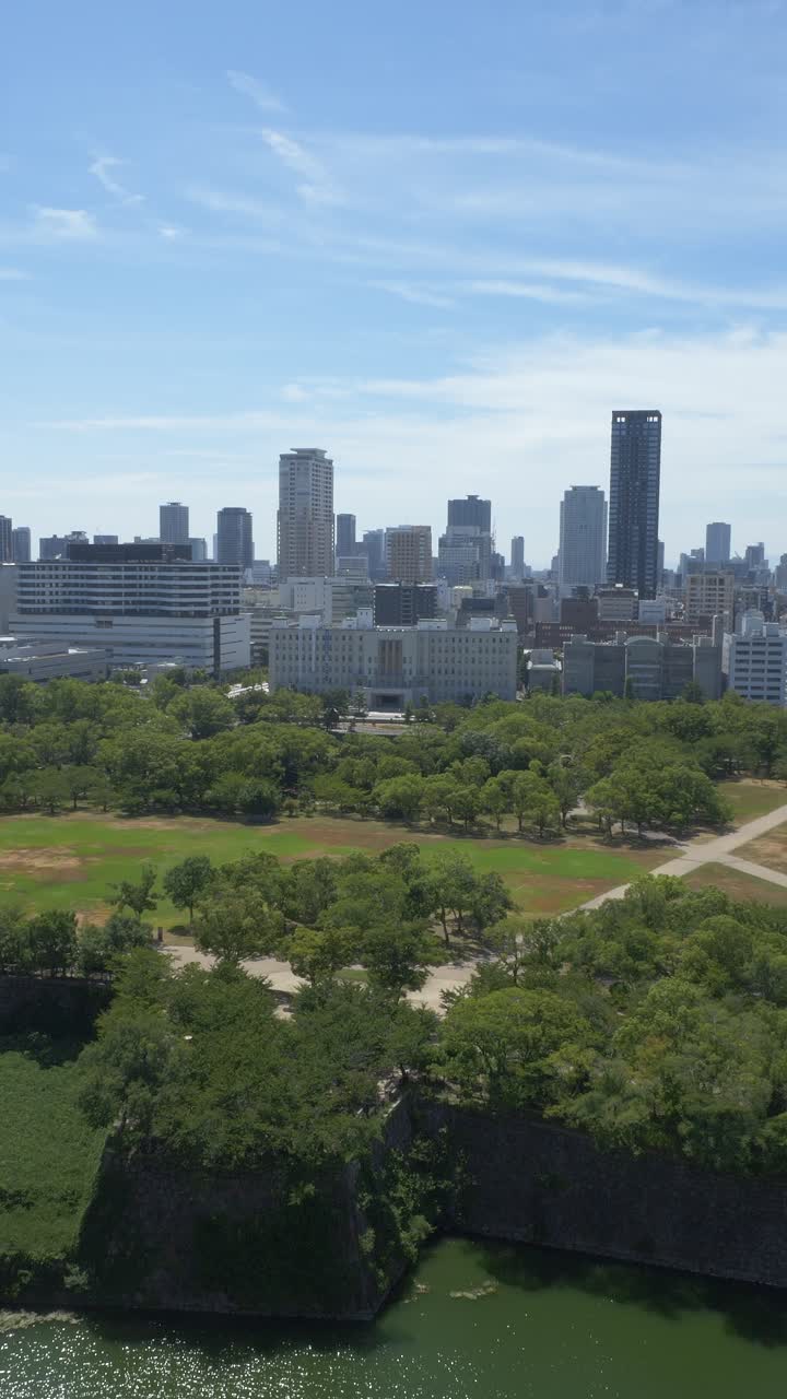 Vertical View Of Osaka Castle Park Green Nature With Modern City Skylines In The Background In Osaka, Japan
