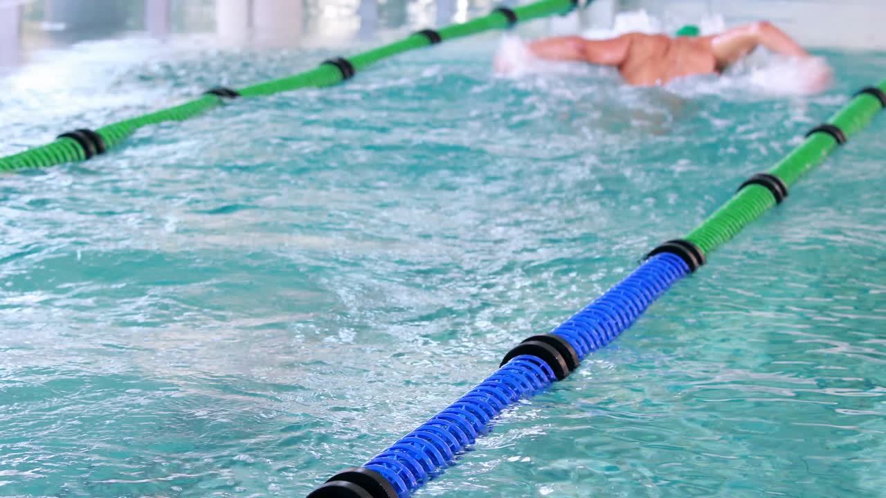 подходящий пловчик делает бабочку в бассейне